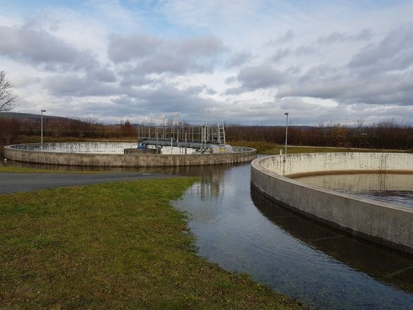 abziehendes Hochwasser um die Klärbecken einer Kläranlage